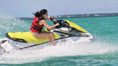 A woman on a white and yellow jet ski in beautiful green water in Destin, Florida