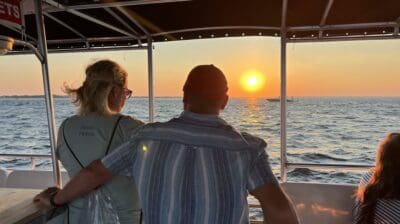 Couple watching the sunset from the boat on a Destin sunset dolphin cruise